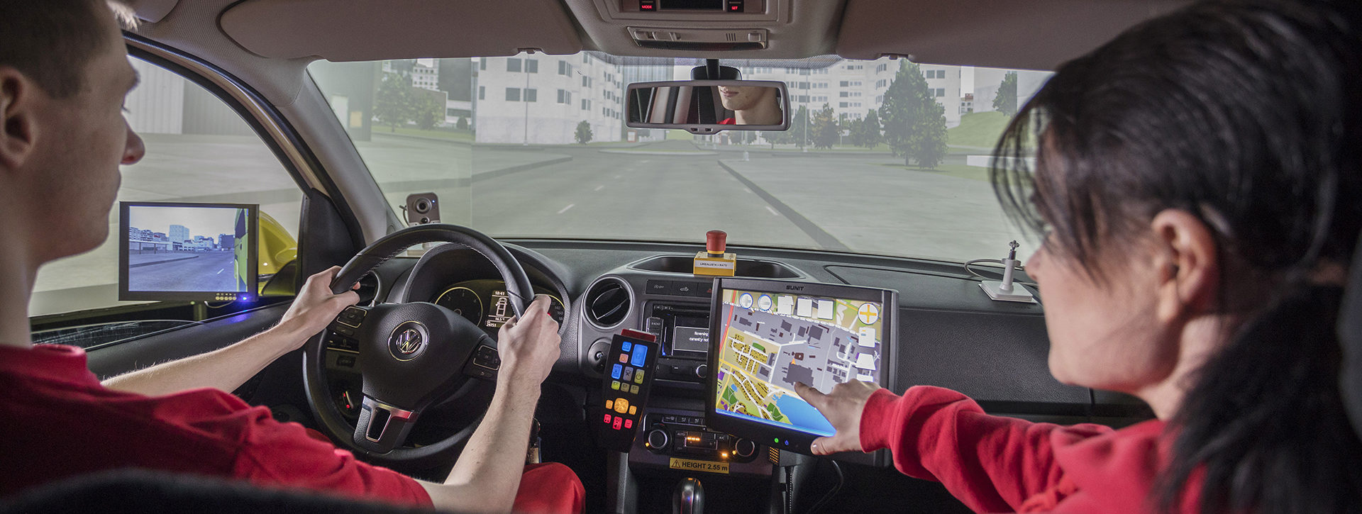 Ensihoitaja opettaja ohjaa opiskelijaa ambulanssisimulaattorissa.