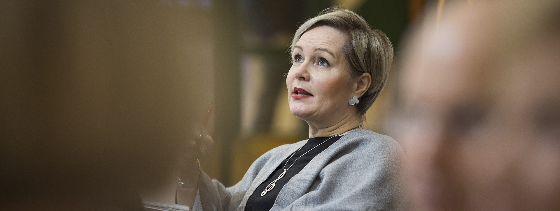 Nainen istuu pöydän ääressä.