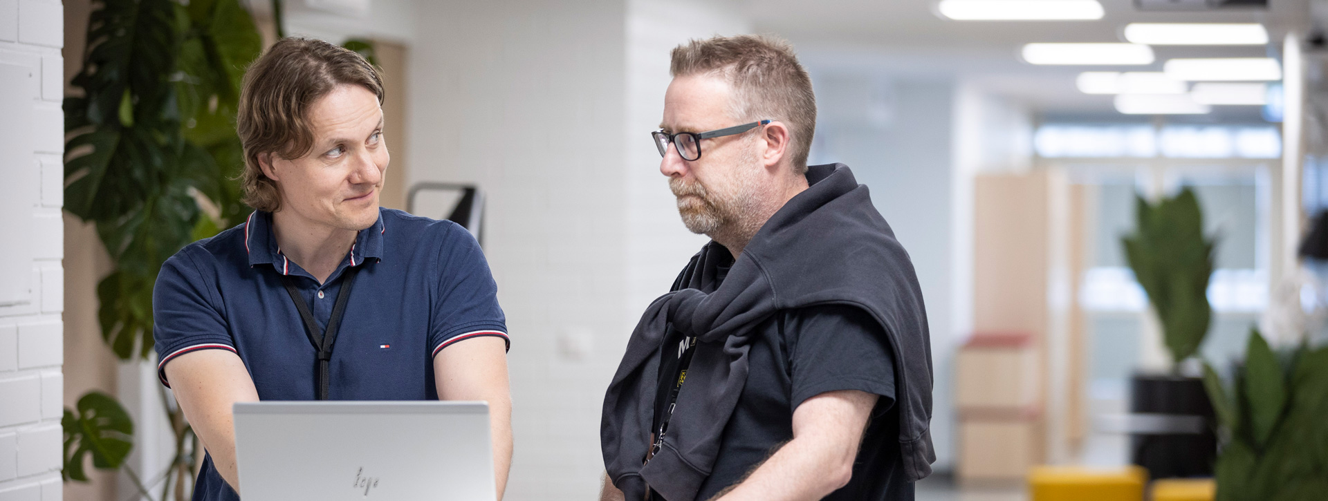 Kaksi ylempi AMK -opiskelijaa keskustelee tietokoneen äärellä