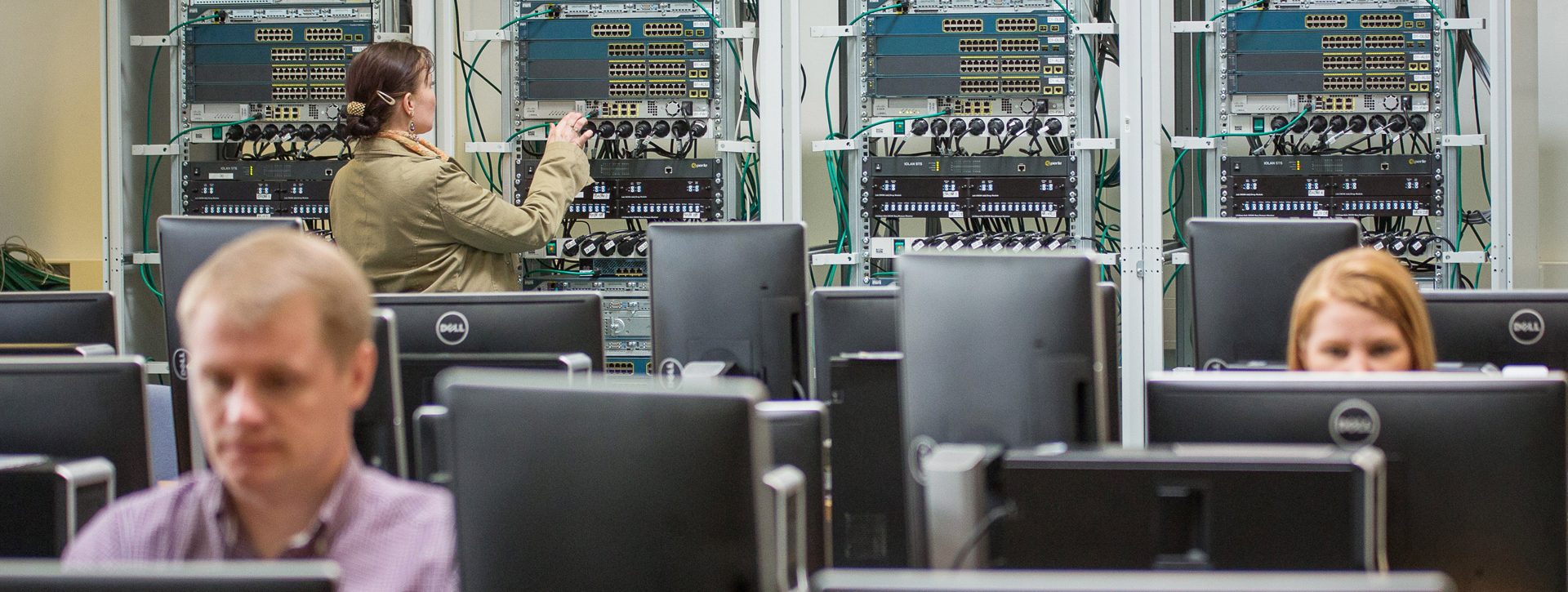 Kolme opiskelijaa työskentelee luokassa.