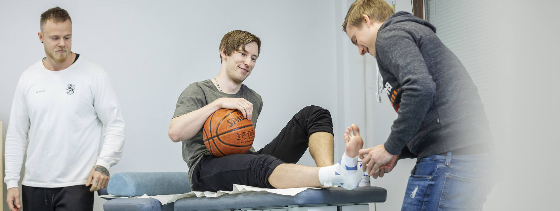 Naprapaatti hoitaa asiakkaan jalkaa hoitopöydällä