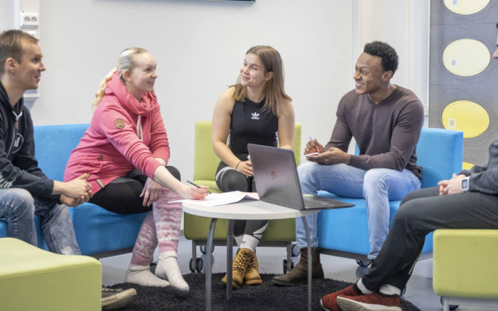 Kouluhyvinvointi ja kuraattorityö -opiskelijat keskustelevat pöydän ympärillä.