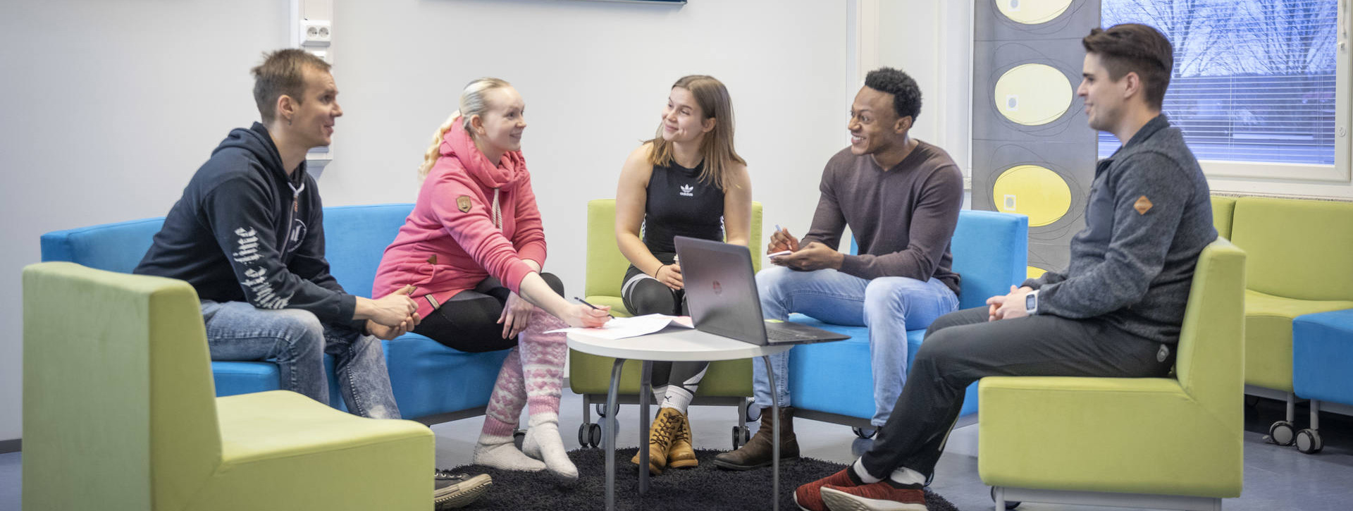 Kouluhyvinvointi ja kuraattorityö -opiskelijat keskustelevat pöydän ympärillä.