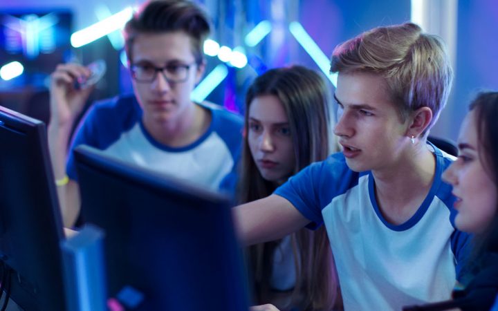 Neljä opiskelijaa katsoo tietokoneen näyttöä.