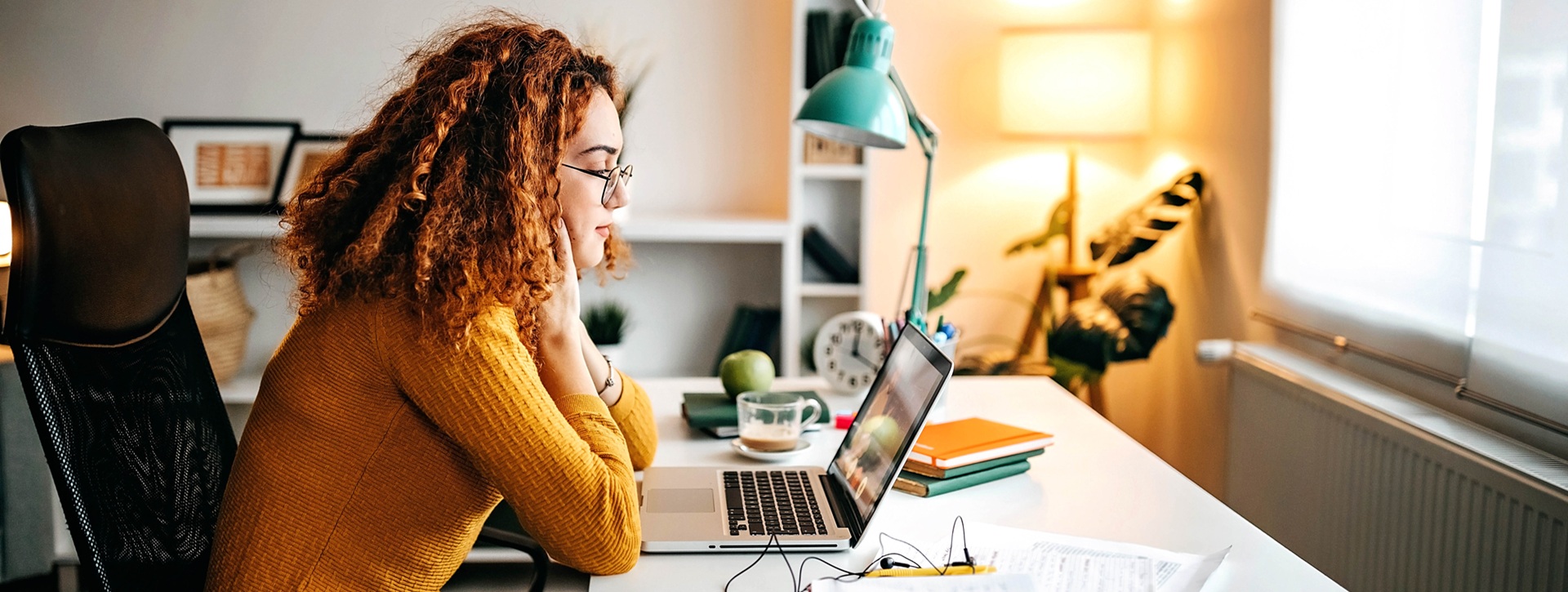 Nuori nainen opiskelemassa kannattavan tietokoneen ääressä.